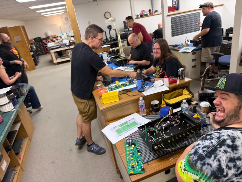Cohort Alpha builders laughing over their chassis at the benches