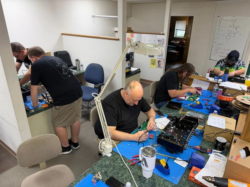 Builders heads-down, soldering at their benches